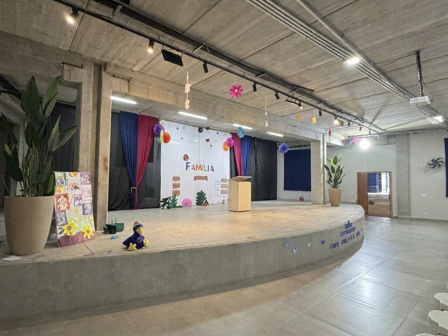 Auditório do Colégio EAG, com palco decorado e iluminação acesa